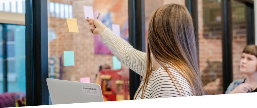 woman placing content marketing planning notes on window wall
